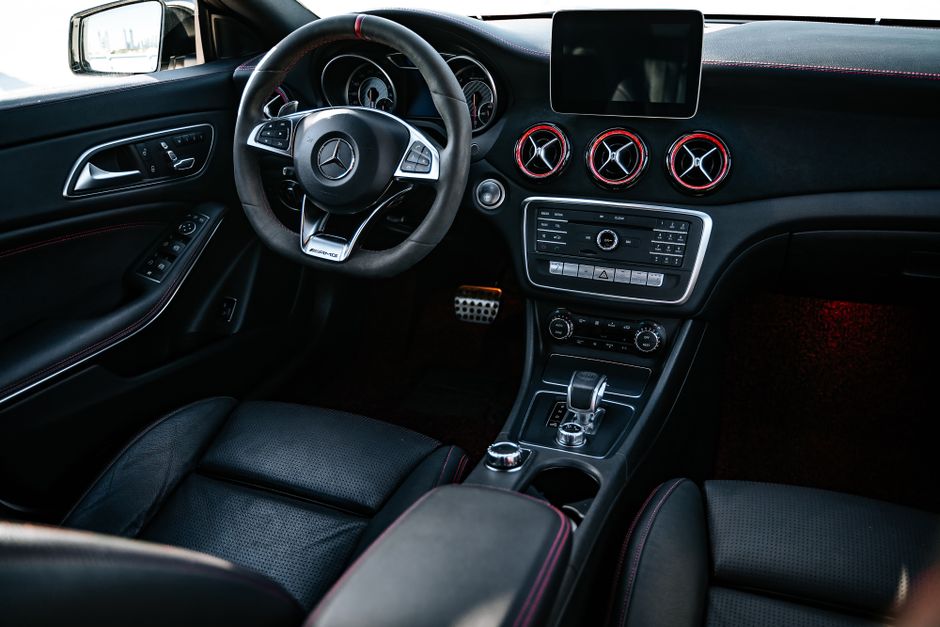 Elegant black car interior showcasing modern dashboard and steering wheel design.