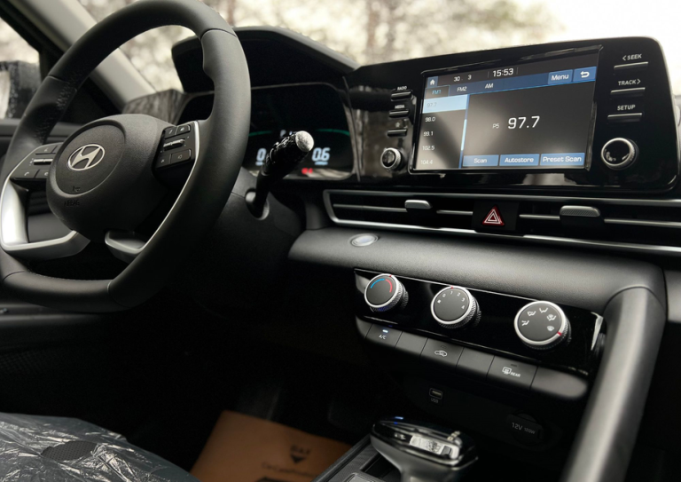 Interior view of a modern car dashboard featuring a touchscreen infotainment system and steering wheel.